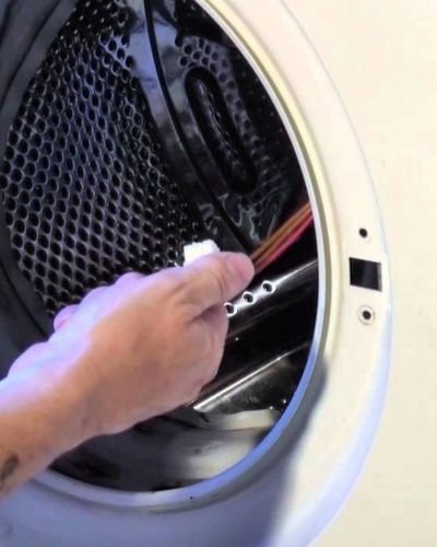 Technician repairing a washing machine door lock and interlock switch